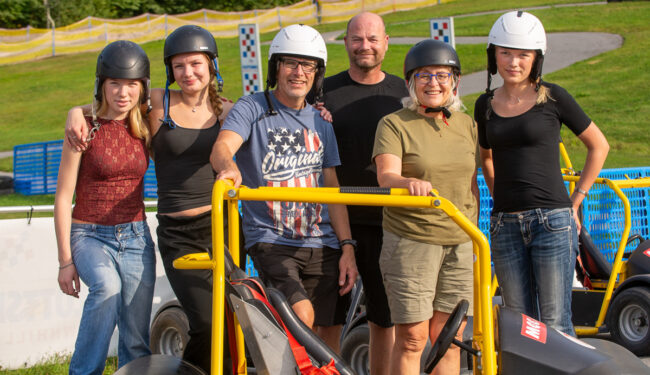 Porträtt på 6 personer med hjälmar som står bakom en av Flottbros Downhill Cars