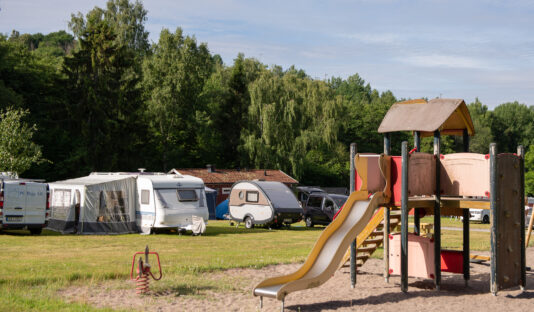 Bild på lekplats på Flottsbro camping, i bakgrunden syns skog.