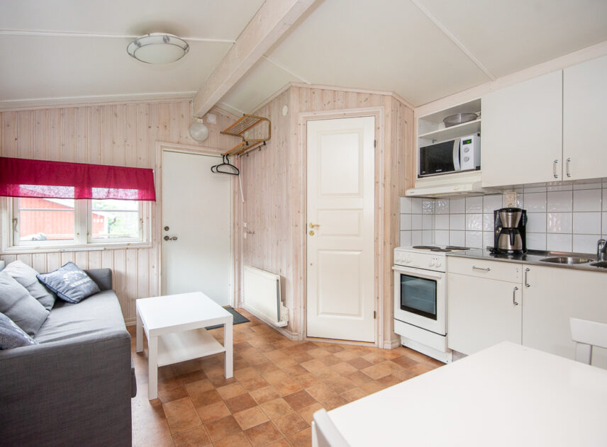 Bild på interiör av stuga med soffa och kök
