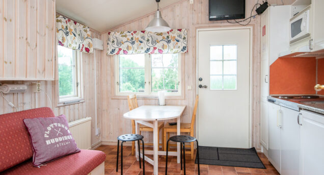Bild på interiör av stuga med soffa.