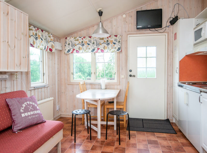 Bild på interiör av stuga med soffa.