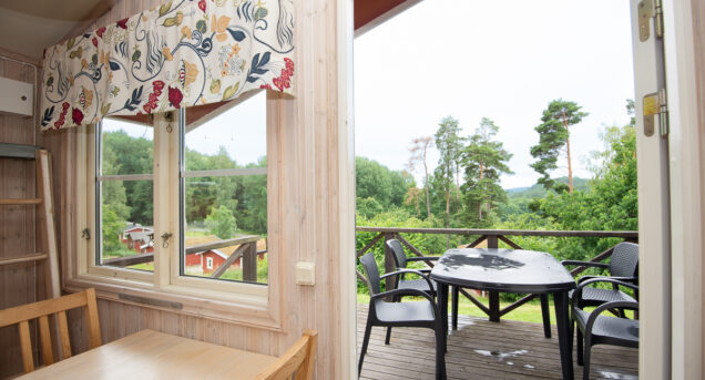 Bild på interiör av stuga med vy över altan