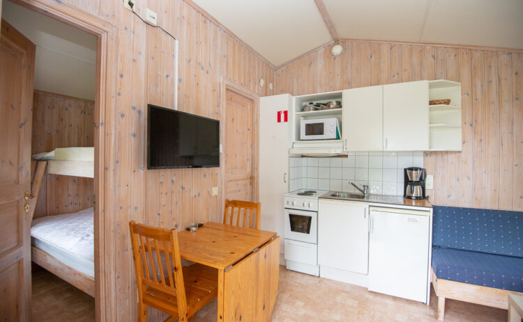 Bilden visar interiör i en av Flottbros stugor med matbord och kök.
