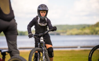 En ungdom tränar balans på cykel, i bakgrunden syns en sjö.