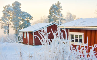 Stugor på Flottsbros camping på vintern med snö och vita träd.