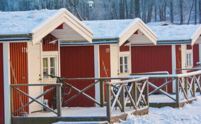 Stugor på Flottsbros camping på vintern med snö och vita träd.