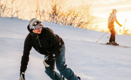 Bidl på snowboardåkare i skidbacke, i bakgrunden syns en annan skidåkare.