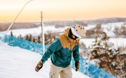 Bild på en snowboardåkare sedd från sidan i en skidbacke.