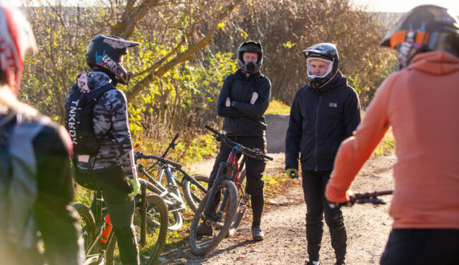 En grupp cyklister som pausar med instruktör i Flottsbro BikePark.