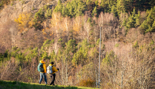2 personer som vandrar ner för Flottbros berg en solig höstdag