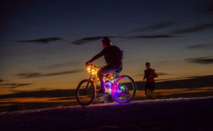 Bild tagen på kvällen på Flottsbro Nightride, cyklist med ljus centralt i bilden, det är mörk bakgrund.