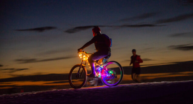 Bild tagen på kvällen på Flottsbro Nightride, cyklist med ljus centralt i bilden, det är mörk bakgrund.