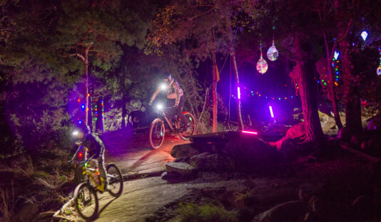 Ungdomar cyklar i en upplyst Bike Park i höstmörkret.