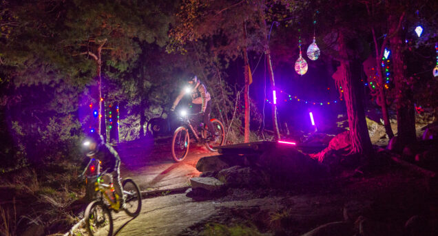 Ungdomar cyklar i en upplyst Bike Park i höstmörkret.