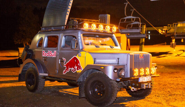 Kvällsbild tagen på en truck med texten Red Bull, gult ljus omger bilen.