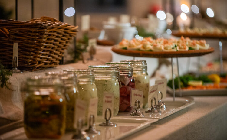 Bild på glasburkar med sill på ett uppdukat julbord.