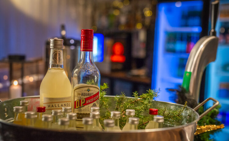 Bild på flaskor med dryck i en balja i en bar.