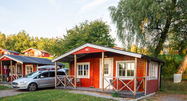 Bilden visar en röd stuga på Flottsbro, nära aktiviteter strax utanför Stockholm.