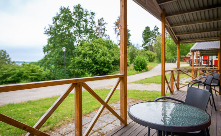 Bild över en altan med utsikt över trädtoppar och ett grönskande landskap.