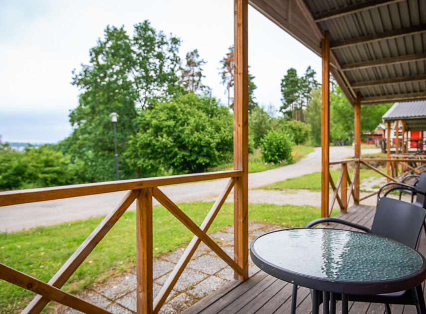 Bild över en altan med utsikt över trädtoppar och ett grönskande landskap.