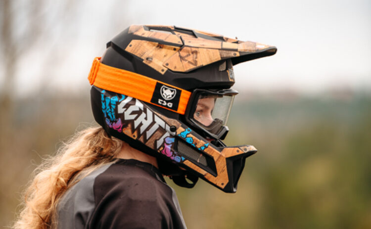 Profilbild av en kvinnlig cyklist med hjälm utomhus sedd i profil.