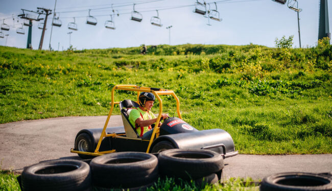 En man åker Downhill Car ner för en backe.