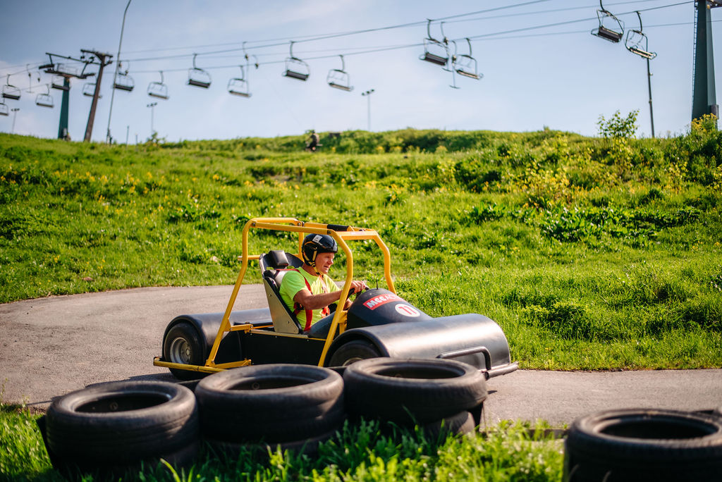 En man åker Downhill Car ner för en backe.