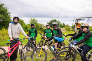 Gruppbild på ledare och ungdomar med cyklar.