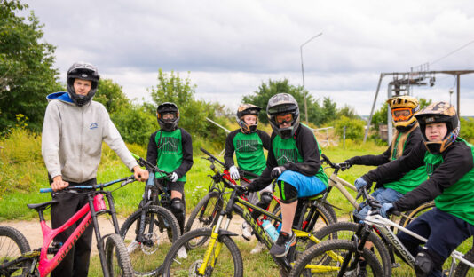 Gruppbild på ledare och ungdomar med cyklar.