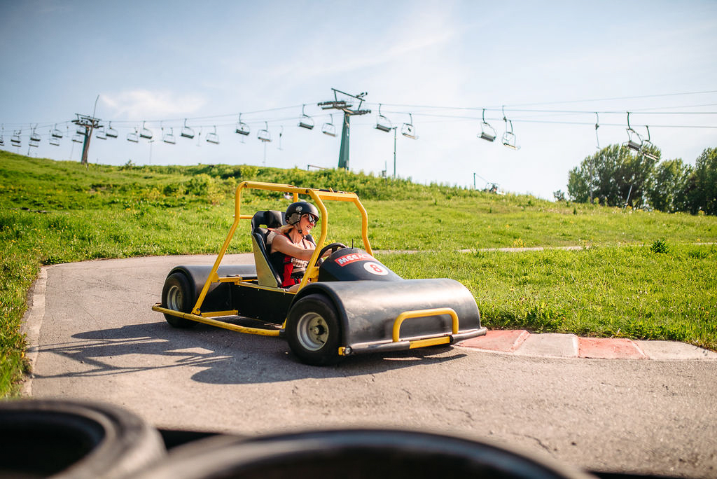 En kvinna åker Downhill Car - en go cart-liknande bil – nedför en skidbacke under sommaren.
