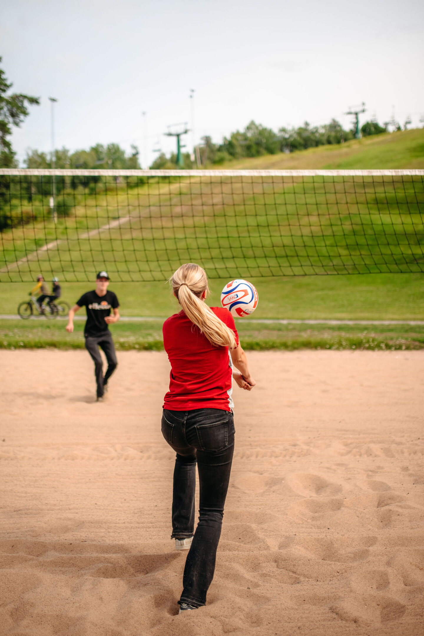 En tjej och en kille spelar beachvolleyboll på sommaren.