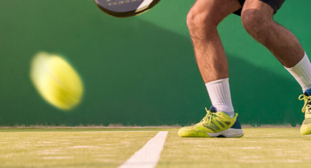 Bild av benen på en person som spelar padle, den gula bollen syns i förgrunden.