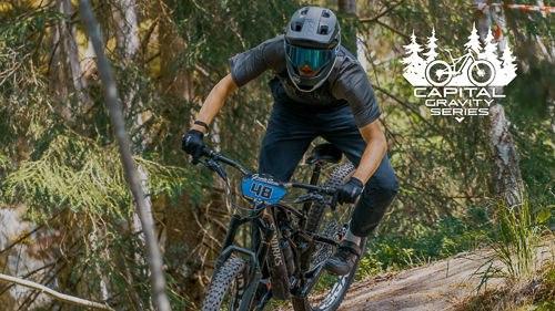 Bild på enduro cyklist som cyklar nedför en backe sedd rakt framifrån.