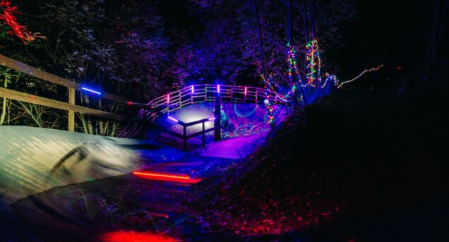 Bike Park i höstmörkret upplyst av färgglada lampor.