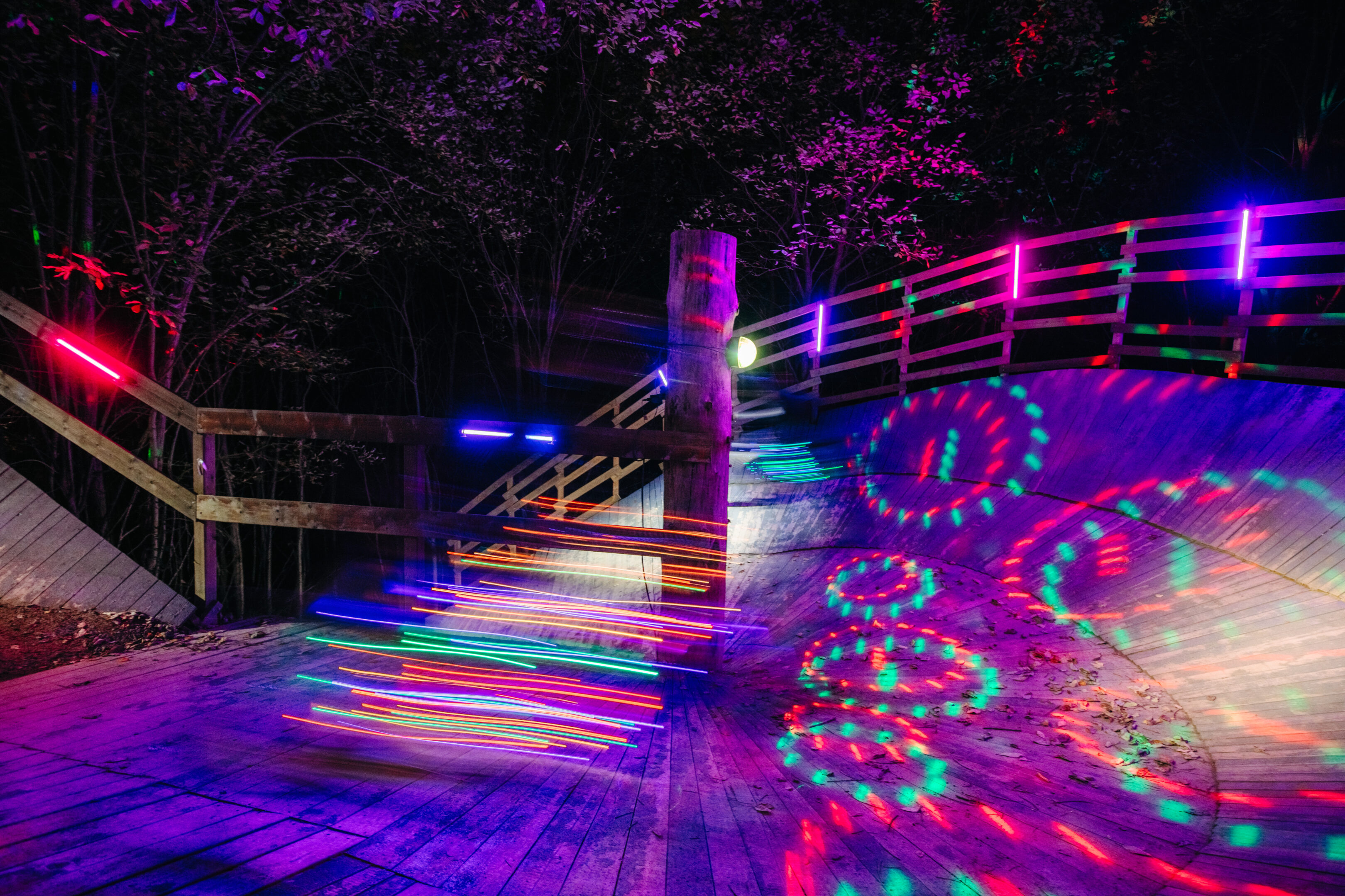Wallride i en Bike Park upplyst med färgglada lampor i höstmörkret.
