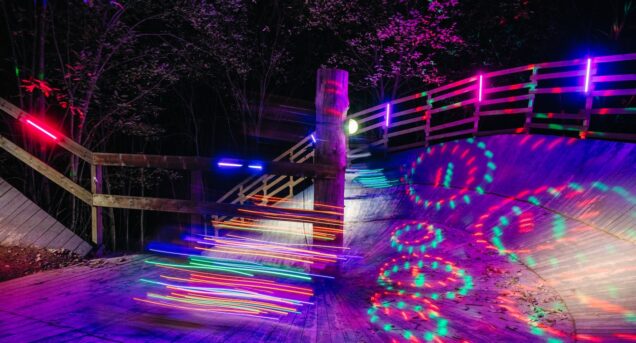 Wallride i en Bike Park upplyst med färgglada lampor i höstmörkret.
