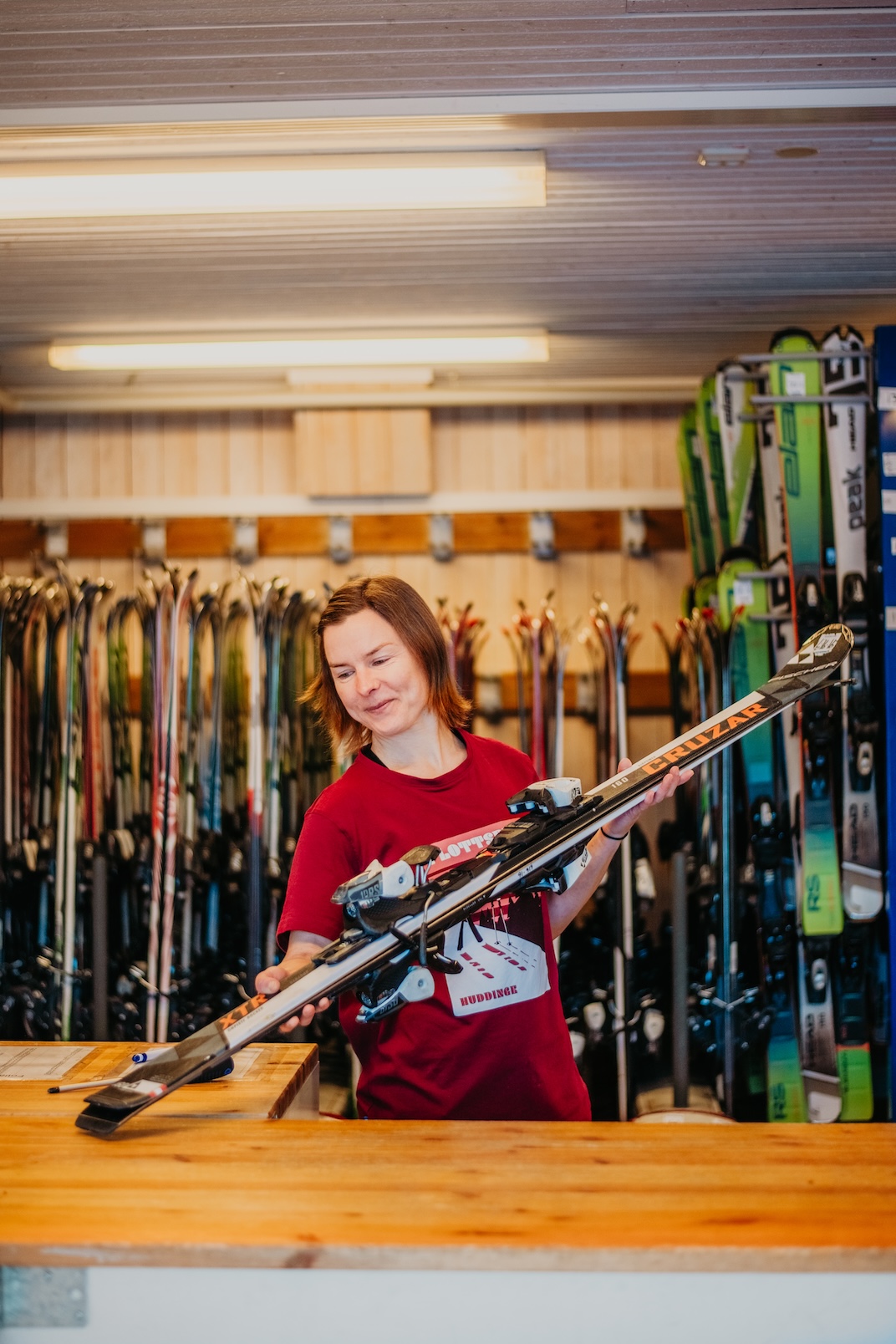 En kvinna bakom en disk till en skiduthyrning.