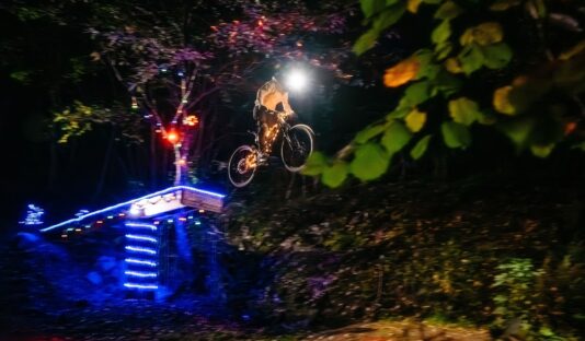 Kille på cykel i bike park under ett kvällsevent.