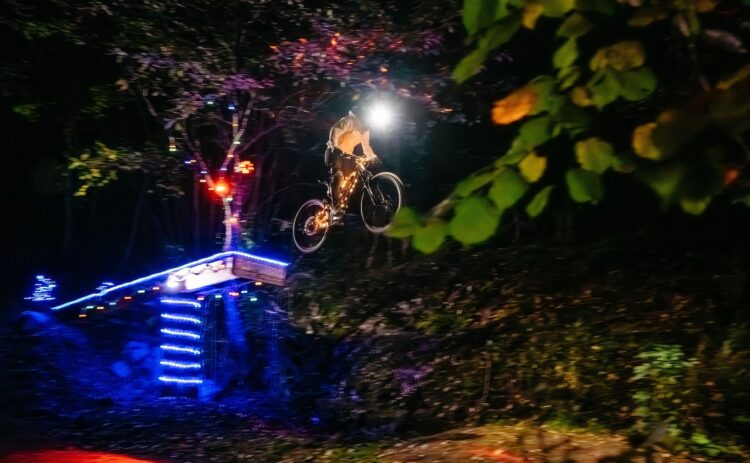 Kille på cykel i bike park under ett kvällsevent.