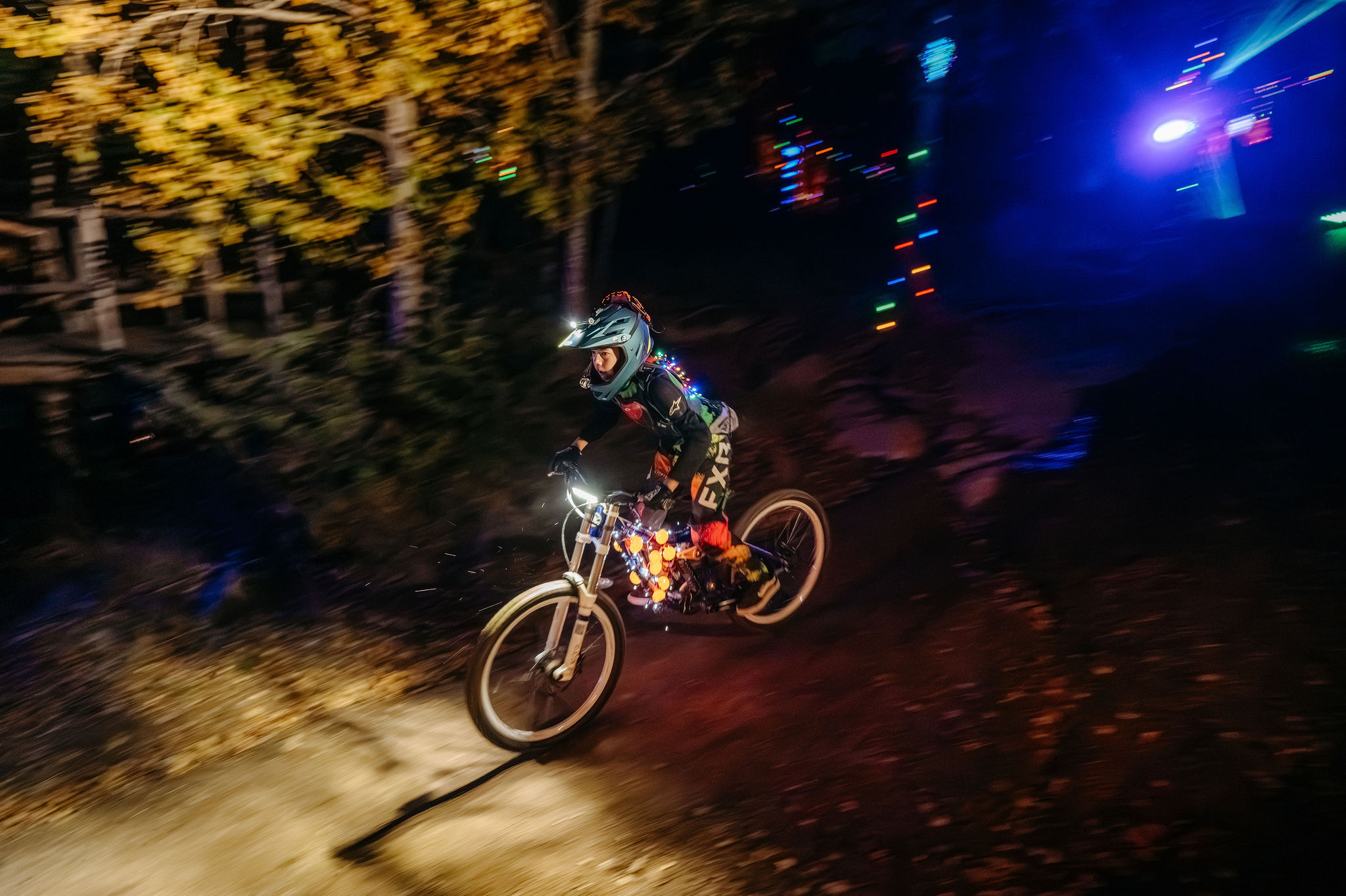 Kille på cykel i bike park under ett kvällsevent.
