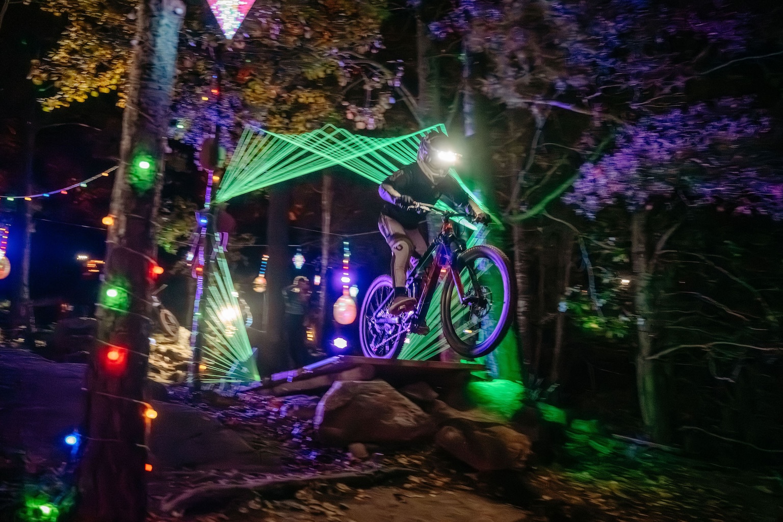 Kille på cykel i bike park under ett kvällsevent.