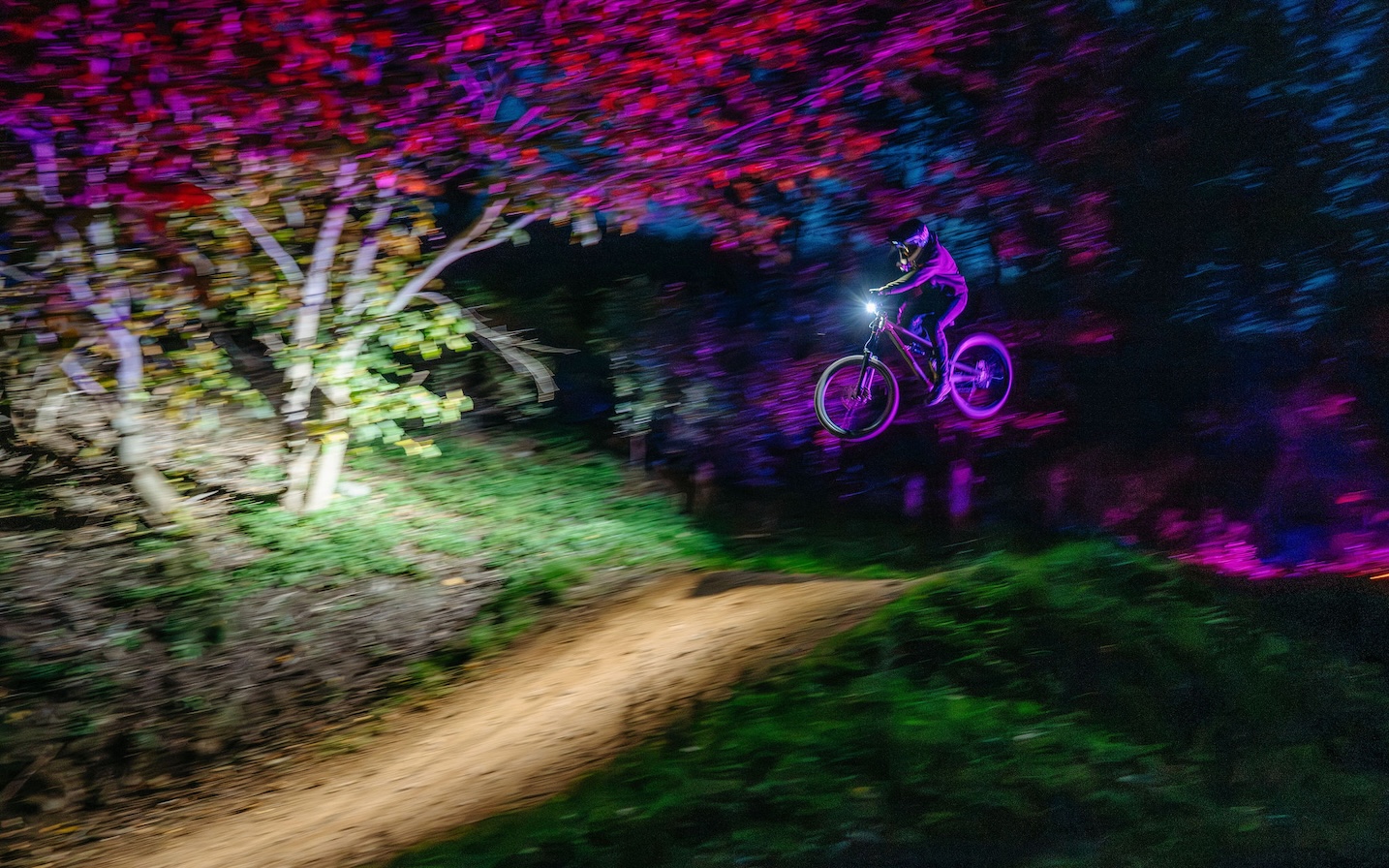 Kille på cykel i bike park under ett kvällsevent.