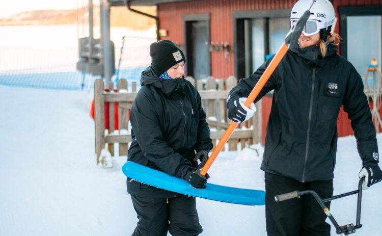 En liftvärd hjälper en åkare med en ankarlift.