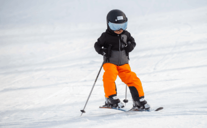 barn som åker skidor i backe